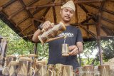 Perajin mencoba menuangkan air dari teko bambu ke dalam gelas bambu saat mengikuti Festival Bambu Kreatif di Taman Pesanggrahan Padjadjaran, Purwakarta, Jawa Barat, Minggu (28/4/2019). Festival tersebut menyajikan hasil kreatifitas perajin bambu untuk mengenalkan seni kreatif bambu dengan harapan dapat meningkatkan daya tarik wisatawan lokal dan mancanegara. ANTARA JABAR/M Ibnu Chazar/agr