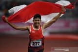 Sprinter Indonesia Sapto Yogo Purnomo berlari sambil membawa bendera Merah-Putih usai menjuarai final 100 meter putra T37 Asian Para Games di Stadion Utama Gelora Bung Karno, Senayan, Jakarta, Selasa (9/10). Sapto berhasil meraih medali emas dengan catatan waktu 11,49 detik. ANTARA JABAR/Sigid Kurniawan/agr