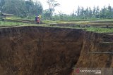 Warga menyaksikan lubang raksasa di area persawahan di Desa Sukamaju, Kadudampit, Kabupaten Sukabumi, Jawa Barat, Minggu (28/4/2019). Lubang raksasa yang memiliki diameter sekitar 16 meter dengan kedalaman 12 meter tersebut belum diketahui penyebabnya. ANTARA JABAR/Aditya Aulia/agr