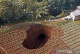 Suasana lubang raksasa di area persawahan di Desa Sukamaju, Kadudampit, Kabupaten Sukabumi, Jawa Barat, Minggu (28/4/2019). Lubang raksasa yang memiliki diameter sekitar 16 meter dengan kedalaman 12 meter tersebut belum diketahui penyebabnya. ANTARA JABAR/Aditya Aulia/agr