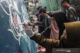 Seniman yang tergabung dalam Street Art Dakwah menyelesaikan pembuatan mural di Kampung Cibunut, Bandung, Jawa Barat, Minggu (28/4/2019). Kegiatan tersebut guna memperindah kampung padat Cibunut dalam menyambut bulan Ramadan 1440 Hijriah sekaligus berdakwah dan menyampaikan pesan agama islam melalui seni grafiti. ANTARA JABAR/Novrian Arbi/agr