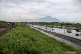 Warga melihat Jalan Raya Porong yang terendam banjir di Porong, Sidoarjo, Jawa Timur, Senin (29/4/2019). Banjir yang diakibatkan curah hujan tinggi sejak Minggu (28/4) malam tersebut mengakibatkan jalan raya Porong terendam air setinggi 60 cm. Antara Jatim/Umarul Faruq/zk.