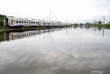 Kereta api melaju di samping Jalan Raya Porong yang terendam banjir di Porong, Sidoarjo, Jawa Timur, Senin (29/4/2019). Banjir yang diakibatkan curah hujan tinggi sejak Minggu (28/4) malam tersebut mengakibatkan jalan raya Porong terendam air setinggi 60 cm. Antara Jatim/Umarul Faruq/zk.