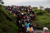 Sejumlah pengendara sepeda motor melewati tanggul penahan lumpur Lapindo untuk menghindari banjir di Porong, Sidoarjo, Jawa Timur, Senin (29/4/2019). Pengendara sepeda motor tersebut tidak bisa melewati jalan raya Porong yang terendam air setinggi 60 cm akibat curah hujan yang tinggi sejak Minggu (28/4) malam. Antara Jatim/Umarul Faruq/zk.