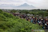 Sejumlah pengendara sepeda motor melewati tanggul penahan lumpur Lapindo untuk menghindari banjir di Porong, Sidoarjo, Jawa Timur, Senin (29/4/2019). Pengendara sepeda motor tersebut tidak bisa melewati jalan raya Porong yang terendam air setinggi 60 cm akibat curah hujan yang tinggi sejak Minggu (28/4) malam. Antara Jatim/Umarul Faruq/zk.