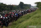 Sejumlah pengendara sepeda motor melewati tanggul penahan lumpur Lapindo untuk menghindari banjir di Porong, Sidoarjo, Jawa Timur, Senin (29/4/2019). Pengendara sepeda motor tersebut tidak bisa melewati jalan raya Porong yang terendam air setinggi 60 cm akibat curah hujan yang tinggi sejak Minggu (28/4) malam. Antara Jatim/Umarul Faruq/zk.