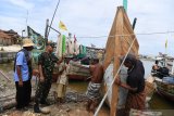 Komandan Sekolah Tinggi Teknologi Angkatan Laut (STTAL) Laksamana Pertama TNI Avando Bastari (kedua kiri) berdialog dengan nelayan ketika meninjau lokasi pengabdian pada masyarakat STTAL di Lamongan, Jawa Timur, Senin (29/4/2019). Melalui pelaksanaan integrasi pengabdian masyarakat civitas akademika STTAL tersebut diharapkan dapat memberikan manfaat kepada masyarakat pesisir khususnya pemberdayaan teknologi kemaritiman dan pelestarian lingkungan hidup. Antara Jatim/Zabur Karuru