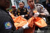 Polisi dan Linmas mengevakuasi korban akibat ledakan truk tangki di Jalan Nambangan 116, Surabaya, Jawa timur, Senin (29/4/2019). Truk tangki tersebut meledak saat dilakukan pengelasan dan menyebabkan satu orang tewas, satu orang terluka dan sejumlah rumah rusak. Antara Jatim/Didik Suhartono/zk.