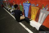 Seniman dari Bengkel Muda Surabaya (BMS) menyelesaikan pembuatan mural Perang Melawan Sampah di Surabaya, Jawa Timur, Selasa (30/4/2019). Mural sepanjang 221 meter tersebut merupakan kampanye untuk mengajak masyarakat agar tidak membuang sampah sembarang terutama sampah plastik dan turut serta menjaga kebersihan lingkungan. Antara Jatim/Moch Asim/zk.