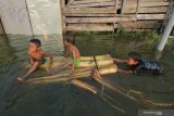 Sejumlah anak bermain air banjir di kawasan Kelurahan Sumberejo, Kecamatan Pakal, Surabaya, Jawa Timur, Jumat (3/5/2019). Banjir yang menggenangi pemukiman di kawasan itu akibat jebolnya tanggul Kali Lamong pada jumat (3/5/2019) dini hari. Antara Jatim/Didik Suhartono/zk.