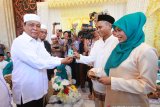 Gubernur Kalsel Sahbirin Noor menyerahkan kartu nikah kepada pasangan penganten saat nikah massal gratis di Masjid Raya Sabilal Muhtadin, Banjarmasin, Kalimantan Selatan, Sabtu (4/5/2019).Baznas Kalsel bersama Kanwil Kemenag Kalsel dan Badan pengelola Masjid Raya Sabilal Muhtadi di dukung Pemprov Kalsel, Bank Kalsel, Persatuan Rias Pengantin Harpi Melati Kalsel dan Yani Yongky Decoration mengadakan nikah massal gratis yang diikuti 50 pasangan penganten tersebut bertujuan untuk membantu masyarakat mendapatkan legalitas pernikahan sesuai ketentuan yang berlaku.Foto Antaranews Kalsel/Bayu Pratama S.