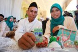 Pasangan pengantin menunjukkan kartu nikah saat nikah massal gratis di Masjid Raya Sabilal Muhtadin, Banjarmasin, Kalimantan Selatan, Sabtu (4/5/2019). Baznas Kalsel bersama Kanwil Kemenag Kalsel dan Badan pengelola Masjid Raya Sabilal Muhtadi di dukung Pemprov Kalsel, Bank Kalsel, Persatuan Rias Pengantin Harpi Melati Kalsel dan Yani Yongky Decoration mengadakan nikah massal gratis yang diikuti 50 pasangan penganten tersebut bertujuan untuk membantu masyarakat mendapatkan legalitas pernikahan sesuai ketentuan yang berlaku.Foto Antaranews Kalsel/Bayu Pratama S.