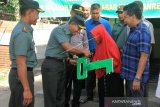 Komandan Resort Militer 012/Teuku Umar Kolonel Inf Aswardi (kedua kiri) bersama Komandan Distrik Militer 0105/Aceh Barat Letkol Kav Nurul Diyanto (kiri) menyerahkan rumah bantuan untuk warga miskin di Desa Ujong Tanoh Darat, Kecamatan Meureuboe, Aceh Barat, Aceh, Jumat (3/5/2019). Sebanyak enam unit Rumah Tidak Layak Huni (RTLH) milik warga miskin dan satu unit mushala direhab sebagai bentuk wujud dalam mensejahterakan rakyak. (ANTARA FOTO/Syifa Yulinnas/ama)