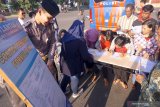 Petugas melayani warga yang mengurus perpanjangan Surat Izin Mengemudi (SIM) di sentra layanan SIM Keliling di lapangan GOR Lembupeteng, Tulungagung, Jawa Timur, Rabu (8/5/2019). Khusus selama bulan Ramadan ini Satpas Polres Tulungagung menyelenggarakan pelayanan perpanjangan SIM A/C bagi warga pada hari Rabu, Kamis dan Sabtu mulai pukul 15.00 WIB hingga 17.30 WIB sembari ngabuburit menunggu jam buka puasa. Antara Jatim/Destyan Sujarwoko/zk.
