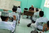 Pendiri Pesantren Al Hidayah yang merupakan mantan terpidana kasus terorisme Khairul Ghazali (atas) memberi bimbingan kepada para santrinya di Desa Sei Mencirim, Deli Serdang, Sumatera Utara, Rabu (8/5/2019). Pesantren yang didirikan mantan terpidana kasus terorisme Khairul Ghazali yang didukung oleh Badan Nasional Penanggulangan Terorisme (BNPT) tersebut saat ini memiliki 16 orang santri anak pelaku terorisme dan masyarakat umum dan diharapkan dapat mengantisipasi berkembangnya ajaran radikalisme di lingkungan masyarakat. ANTARA FOTO/Irsan Mulyadi/nym.