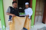 Marketing Manager Radio Karimata FM Syamsul Arifin (kiri) menyerahkan Al Quran dan sajadah kepada takmir Musholla Baiturrahman di Kelurahan Gladak Anyar,   Pamekasan, Jawa Timur, Kamis (9/5/2019). Sedikitnya seribu Al Quran dan ratusan sajadah hasil donasi dari pendengar radio tersebut diserahkan ke Masjid dan Mushalla, guna memenuhi Al Quran dibulan Ramadhan 1440 H. Antara Jatim/Saiful Bahri/zk.