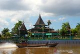 Perahu bermesin (kelotok) melintas di sungai kuin berlatar Masjid Sultan Suriansyah Banjarmasin, Kalimantan Selatan, Kamis (9/5/2019).Masjid Sultan Suriansyah merupakan masjid bersejarah dan salah satu masjid tertua di Kalsel berbahan kayu ulin yang menjadi salah satu tujuan wisata religi di Kalimantan Selatan. Foto Antaranews Kalsel/Bayu Pratama S.