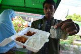 Anggota Lembaga Sosial Pesantren Tebuireng (LSPT) menunjukkan nasi kotak dengan lauk ayam yang dijual Rp2 ribu di Warung Nabung Berkah di Jombang, Jawa Timur, Kamis (9/5/2019). Setiap hari Warung Nabung Berkah menyediakan 150 kotak nasi untuk orang-orang yang kurang beruntung secara ekonomi. Antara Jatim/Syaiful Arif/zk.