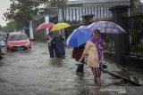 Warga melintasi banjir yang menggenangi Jalan Cingised, Bandung, Jawa Barat, Kamis (9/5/2019). Banjir setinggi 30 hingga 60 sentimeter kembali menggenangi beberapa wilayah di Kota Bandung akibat hujan lebat pada Kamis (9/5) sejak siang hingga sore hari. ANTARA JABAR/Raisan Al Farisi/agr