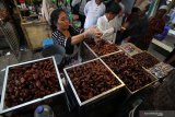 Pedagang kurma melayani pembeli di salah satu stan di kawasan wisata religi Makam dan Masjid Sunan Ampel, Surabaya, Jawa Timur, Jumat (10/5/2019). Kawasan tersebut menjadi salah satu pusat penjualan berbagai macam jenis kurma di Surabaya yang dijual mulai harga Rp30.000 hingga Rp300.000 per kilogram. Antara Jatim/Moch Asim/zk.