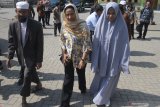 Menteri Badan Usaha Milik Negara (BUMN), Rini Soemarno (tengah) berjalan didampingi pengasuh Panti Asuhan dan Pondok Pesantren Al Ikhlas, Ustadz Muhammad Ali Zubair (kiri) dan Ustazah Dina Maulida (kanan) dalam kunjungan kerja di Malang, Jawa Timur, Senin (13/5/2019). Dalam kunjungannya, Mentreri BUMN juga menyerahkan bantuan dari Bank BNI untuk pembangunan ponpes panti asuhan tersebut.Antara Jatim/Ari Bowo Sucipto/ZK