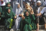 Menteri Badan Usaha Milik Negara (BUMN), Rini Soemarno (dua dari kanan) berbincang dengan santri didampingi pengasuh Panti Asuhan dan Pondok Pesantren Al Ikhlas, Ustadz Muhammad Ali Zubair (kanan) dan Ustazah Dina Maulida (dua kiri) dalam kunjungan kerja di Malang, Jawa Timur, Senin (13/5/2019). Dalam kunjungannya, Mentreri BUMN juga menyerahkan bantuan dari Bank BNI untuk pembangunan ponpes panti asuhan tersebut. Antara Jatim/Ari Bowo Sucipto/ZK