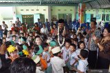 Walikota Madiun Maidi (tengah) bernyanyi bersama siswa TK Santo Bernardus dan TK Aisyiyah Bustanul Athfal (ABA) saat melakukan kunjugan di TK Santo Bernardus Kota Madiun, Jawa Timur, Selasa (14/5/2019). Kegiatan bersama antarlembaga TK beda agama tersebut dimaksudkan untuk mengajari anak sejak dini tentang pentingnya toleransi antarumat beragama. Antara Jatim/Siswowidodo/zk.