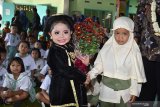 Siswa TK Santo Bernardus (kiri) menerima untaian bunga dari siswa TK Aisyiyah Bustanul Athfal (ABA) saat melakukan kunjugan di TK Santo Bernardus Kota Madiun, Jawa Timur, Selasa (14/5/2019). Kegiatan bersama antarlembaga TK beda agama tersebut dimaksudkan untuk mengajari anak sejak dini tentang pentingnya toleransi antarumat beragama. Antara Jatim/Siswowidodo/zk.