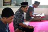 Tiga warga binaan menjalankan ibadah salat dan membaca kitab suci Al Quran di Masjid Miftahul Jannah di Lapas Klas IIA Pontianak di Sungai Raya, Kabupaten Kubu Raya, Kalimantan Barat, Senin (13/5/2019). Lapas Klas IIA Pontianak mengadakan sejumlah kegiataan pembinaan rohani bagi warga binaan beragama Islam yaitu belajar mengaji, membaca Al Quran, ceramah dan salat berjamaah yang digelar setiap hari selama bulan ramadan. ANTARA FOTO/Jessica Helena WuysangANTARA FOTO/JESSICA HELENA WUYSANG (ANTARA FOTO/JESSICA HELENA WUYSANG)