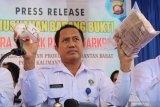 Kepala Badan Narkotika Nasional (BNN) Kalbar Brigjen Pol Suyatmo memperlihatkan sabu dan uang hasil tangkapan saat pemusnahan barang bukti di Kantor BNNP Kalbar di Pontianak, Kalbar, Selasa (13/5/2019). BNNP Kalbar memusnahkan 1,3 Kilogram sabu juga menyita uang tunai sebanyak Rp169 Juta serta beberapa buku tabungan dari dua tersangka pengedar narkoba yaitu Maskur dan Badol yang ditangkap di kawasan Pontianak Utara pada 26 April 2019. ANTARA FOTO/Jessica Helena WuysangANTARA FOTO/JESSICA HELENA WUYSANG (ANTARA FOTO/JESSICA HELENA WUYSANG)