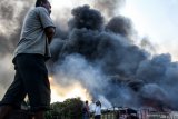 Warga melihat kobaran api yang membakar sebuah gudang tempat penyimpanan dan pengemasan karton bekas di kawasan Kletek, Taman, Sidoarjo, Jawa Timur, Selasa (14/5/2019).  Sebanyak enam pemadam kebakaran dikerahkan ke lokasi tersebut dan penyebab kebakaran masih belum diketahui. Antara Jatim/Umarul Faruq/zk.