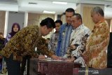 Ketua KPK Agus Rahardjo (kanan) bersama Gubernur Sumut Edy Rahmayadi (kedua kanan) Wakil Gubernur Musa Rajekshah (ketiga kanan) menyaksikan Komisaris BUMD PT Dhirga Surya Walid Musthafa Sembiring (kiri) menandatangani berkas pada Rakor Pencegahan Korupsi Terintegrasi se Provinsi Sumut, di Medan, Sumatera Utara, Selasa (14/5/2019). Rakor yang diikuti para Wali Kota dan Bupati se Sumut, direksi dan komisaris BUMD tersebut dalam rangka pencegahan korupsi di lingkungan pemerintahan daerah. (Antara Sumut/Irsan)