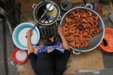 Seorang warga membuat kue Keukarah atau kue kering khas tradisional Aceh di salah satu tempat pembuatan kue kering usaha rumahan Desa Langgung, Kecamatan Meureubo, Aceh Barat, Selasa (14/5/2019). Pelaku usaha kue kering di kawasan itu mengaku sejak sepekan terakhir permintaan kue kering tradisional mengalami peningkatan dari 300 buah per hari menjadi 1.500 buah per hari dengan harga jual Rp 1.000 per buah. (Antara Aceh/Syifa Yulinnas)