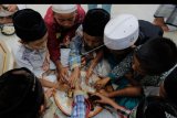 Umat Islam menggelar tradisi Megibung atau makan bersama dalam satu piring seperti tradisi Hindu di Bali saat berbuka puasa bersama di Masjid Al-Muhajirin, Denpasar, Bali, Rabu (15/5/2019). Tradisi megibung tersebut merupakan budaya Bali yang rutin dilaksanakan Muslim Kampung Kepaon, Denpasar setiap hari ke-10 berpuasa di bulan Ramadhan, untuk memupuk rasa kebersamaan. ANTARA FOTO/Nyoman Hendra Wibowo/nym/