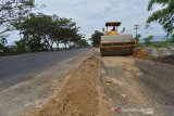 Pekerja mengoperasikan alat berat membangun pelebaran jalan nasional di desa Indrapuri, Kabupaten Aceh Besar, Kamis (16/5/2019). Pelebaran jalan nasional lintas Banda Aceh-Sumut itu untuk mempelancar arus kendaraan, termasuk arus mudik lebaran Idul Fitri. (Antara Aceh/Ampelsa)
