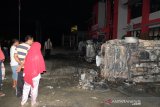 Warga melihat bangkai mobil yang rusak dampak kerusuhan di Lapas Narkotika Kelas III Langkat, di Langkat, Sumatera Utara, Kamis (16/5/2019). Akibat peristiwa kerusuhan yang dilakukan para narapidana di Lapas tersebut mengakibatkan tiga mobil dan dua sepeda motor petugas rusak terbakar dan ratusan napi melarikan diri. (Antara Sumut/Irsan)