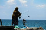 Warga membuang sampah rumah tangga ke laut di pesisir pantai Kampung Jawa, Lhokseumawe, Aceh, Selasa (14/5/2019). Tindakan tersebut menyebabkan pencemaran di laut dan merusak ekosistemnya. ANTARA FOTO
