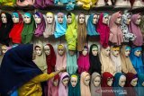 Pembeli menata jilbab di salah satu pusat penjualan busana muslimah di Lhokseumawe, Aceh, Jumat (17/5/2019). Menurut pedagang, permintaan jilbab untuk kebutuhan Lebaran tahun ini meningkat hingga 70 persen dari sebelumnya, dengan harga jual Rp35.000-Rp180.000 per jilbab tergantung model, merek dan kualitas kain. (Antara Aceh/Rahmad)