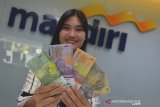 Petugas Bank Mandiri Kantor Cabang Pembantu (KCP) Tasikmalaya menunjukan uang pecahan untuk layanan penukaran uang baru di Kota Tasikmalaya, Jawa Barat, Jumat (17/5/2019). Bank Mandiri menyiapkan dana tunai sebesar Rp54,9 triliun atau sekitar Rp1,9 triliun per hari secara Nasional untuk mengantisipasi kenaikan kebutuhan masyarakat pada Bulan Ramadan dan menjelang Idul Fitri 1440 H. ANTARA JABAR/Adeng Bustomi/agr