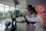 Petugas Kantor Kesehatan Pelabuhan kelas 1 Surabaya wilayah kerja bandara Juanda melihat alat pendeteksi suhu tubuh (thermal scanner) saat penumpang pesawat tiba di terminal 2 Bandara Juanda Surabaya di Sidoarjo, Jawa Timur, Jumat (17/5/2019). Kantor Kesehatan Pelabuhan kelas 1 Surabaya wilayah kerja bandara Juanda meningkatkan kewaspadaan dengan memasang alat pendeteksi suhu tubuh untuk mengantisipasi masuknya virus cacar monyet (Monkeypox) ke wilayah Indonesia. Antara Jatim/Umarul Faruq/zk.