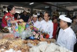 Presiden Joko Widodo (kedua kanan) didampingi Wali Kota Denpasar Ida Bagus Rai Dharmawijaya Mantra (kanan) berbincang dengan pedagang saat mengunjungi Pasar Badung di Denpasar, Bali, Sabtu (18/5/2019). Dalam kunjungan tersebut, Presiden mengapresiasi penggunaan tas belanja ramah lingkungan di pasar tersebut dan membeli sejumlah buah-buahan untuk santapan berbuka puasa. ANTARA FOTO/Fikri Yusuf/nym.