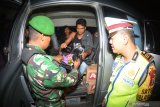 Personel gabungan Polri, TNI melakukan pemeriksaan identitas penumpang kendaraan di jalan raya Pantura Situbondo, Jawa Timur, Sabtu (18/5/2019) malam. Pemeriksaan kendaraan beserta penumpang dan barangnya tersebut untuk mengantisipasi pergerakan massa yang akan berangkat ke Jakarta menjelang pengumuman hasil rekapitulasi suara Pemilu 2019 di kantor KPU. Antara Jatim/Seno/zk.