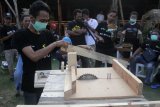 Anggota komunitas perajin kayu mengajari seorang penyandang disabilitas mengolah limbah kayu menjadi benda kerajinan dalam kegiatan bertajuk Kelas Kayu Difabel di Malang, Jawa Timur, Minggu (19/5/2019). Kegiatan tersebut diharapkan mampu memberikan pengetahuan dan keahlian bagi para penyandang disabilitas agar lebih produktif, kreatif, mandiri serta mempunyai penghasilan sendiri. Antara Jatim/Ari Bowo Sucipto/zk.