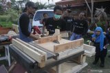 Anggota komunitas perajin kayu mengajari seorang penyandang disabilitas mengolah limbah kayu menjadi benda kerajinan dalam kegiatan bertajuk Kelas Kayu Difabel di Malang, Jawa Timur, Minggu (19/5/2019). Kegiatan tersebut diharapkan mampu memberikan pengetahuan dan keahlian bagi para penyandang disabilitas agar lebih produktif, kreatif, mandiri serta mempunyai penghasilan sendiri. Antara Jatim/Ari Bowo Sucipto/zk.