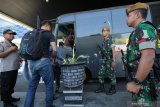 Polisi berpakaian sipil dan personel TNI mengawal sejumlah orang menuju bus polisi di Gapura Surya Nusantara, Pelabuhan Tanjung Perak, Surabaya, Jawa Timur, Senin (20/5/2019). Pihak kepolisian memulangkan 24 penumpang KM Mutiara Ferindo 5 dari Kalimantan Selatan yang diduga hendak ke Jakarta terkait pengumuman hasil pemilihan presiden pada Rabu, 22 Mei 2019 di KPU. Antara Jatim/Didik Suhartono/zk.