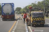 Sejumlah pekerja menyelesaikan proses pengecatan marka jalan di jalur pantura Lohbener Indramayu, Jawa Barat, Senin (20/5/2019). Pengecatan marka jalan tersebut untuk meningkatkan keselamatan dan kenyamanan pemudik yang melintas saat mudik Lebaran 2019. ANTARA JABAR/Dedhez Anggara/agr