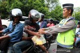 Para anggota Ditlantas Polda Kalbar membagikan takjil ke pengendara di Jalan Ahmad Yani, Pontianak, Kalimantan Barat, Kamis (16/5/2019) sore. Selain berbagi takjil, kegiatan ini juga merupakan operasi keselamatan berlalu lintas bagi pengguna jalan. ANTARA FOTO/Jessica Helena Wuysang