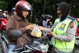 Para anggota Ditlantas Polda Kalbar membagikan takjil ke pengendara di Jalan Ahmad Yani, Pontianak, Kalimantan Barat, Kamis (16/5/2019) sore. Selain berbagi takjil, kegiatan ini juga merupakan operasi keselamatan berlalu lintas bagi pengguna jalan. ANTARA FOTO/Jessica Helena Wuysang