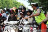 Para anggota Ditlantas Polda Kalbar membagikan takjil ke pengendara di Jalan Ahmad Yani, Pontianak, Kalimantan Barat, Kamis (16/5/2019) sore. Selain berbagi takjil, kegiatan ini juga merupakan operasi keselamatan berlalu lintas bagi pengguna jalan. ANTARA FOTO/Jessica Helena Wuysang