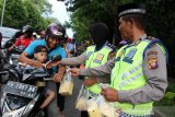 Para anggota Ditlantas Polda Kalbar membagikan takjil ke pengendara di Jalan Ahmad Yani, Pontianak, Kalimantan Barat, Kamis (16/5/2019) sore. Selain berbagi takjil, kegiatan ini juga merupakan operasi keselamatan berlalu lintas bagi pengguna jalan. ANTARA FOTO/Jessica Helena Wuysang